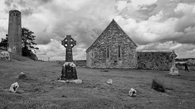 buildings and crosses at the graveyard of Clonmacnoise monastery (monochrome)