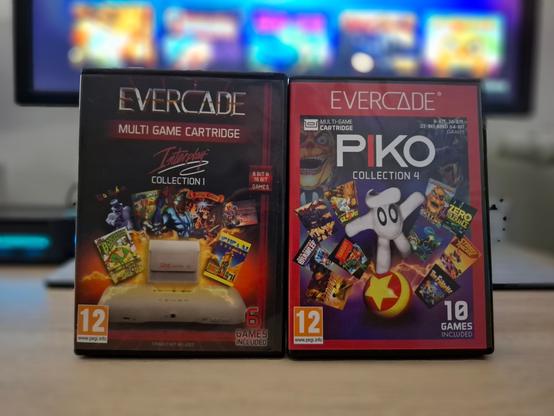 Photo des boitiers de deux compilations de jeux Evercade. A gauche la compil "Interplay collection volume 1" et a droite "Piko collection volume 4".
En arrière-plan flouté, mon moniteur affiche les menus de la console evercade.