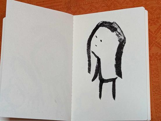 Personnage aux longs cheveux, dessin intuitif au feutre pinceau dans un cahier.