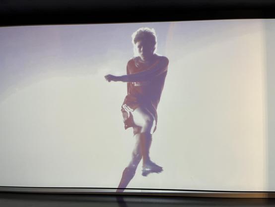 In Großaufnahme und Zeitlupe ist zu jeder Dekade ein Spieler im Trikot und Haarschnitt der Zeit gefilmt, das läuft im Hintergrund auf einem riesenbildschirm und ist sehr ästhetisch. Naja, die schlimme Vokuhila-Frisur des 1990er-Spielers nicht.