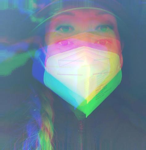 Me, wearing a KN95 mask & a cap hat under a hoodie is pictured with a colorful, glitch effect applied, creating multiple overlapping layers in shades of pink, green & blue, giving the image a surreal & abstract appearance.