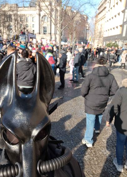 Selfies near the Brandenburg Gate. In the background is the majority of the crowed and one of the trucks. The big building is the Bundestag.
