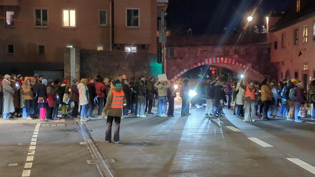 Die Menschen überqueren die Ampel unterhalb der Alten Mainbrücke in Richtung Mainkai.