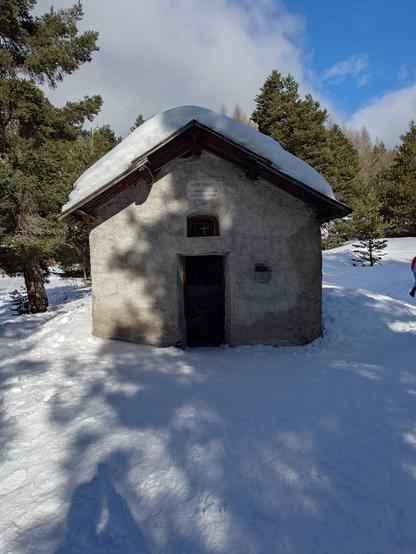 The small Chapelle de Bonne Rencontre with snow on its roof and on the ground