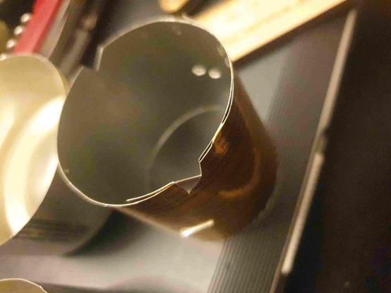 Bande de 43mm de large de canette en alu circularisée et agrafée, et découpée sur le bas sur 3mm en simple entaille au ciseau, entaille repliée pour évider un triangle.