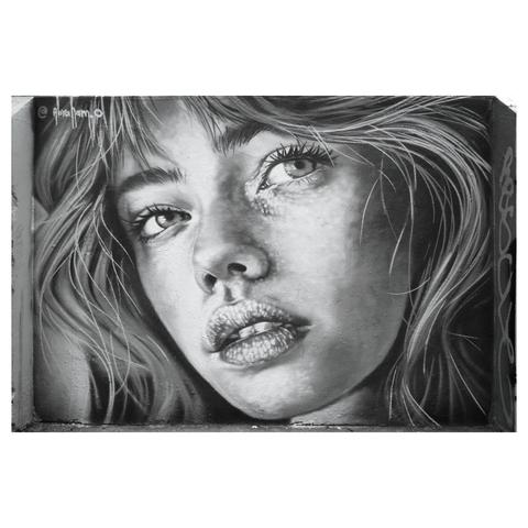 Black and white photo of a street art painting of a girls face on a wall in a Shoreditch side street