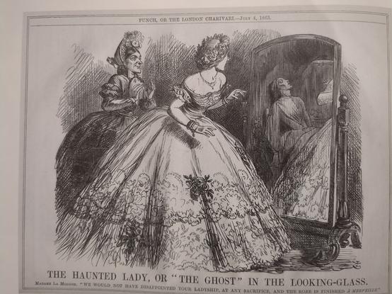 A black and white drawing of a lady in a ballgown, attended by a dressmaker, looking at herself in a large mirror. She is startled at the reflection of a dead seamstress in the mirror, leaning against the wall. 
The caption reads: 
The Haunted Lady; or "The Ghost" In The Looking-Glass. 
Madame la Modiste: "We would not have disappointed your ladyship, at any sacrifice, and the robe is finished à merveille."