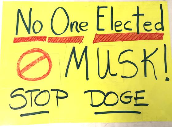 Handwritten sign saying, No one Elected Musk! Stop DOGE