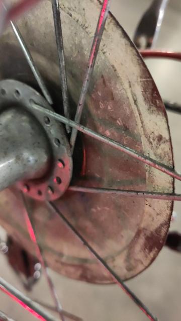 Détail d'un moyeu de roue arrière avec plein de rayons cassés