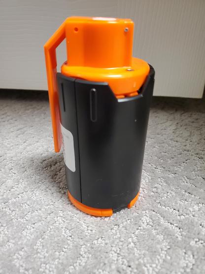 Orange and black "smoke hand grenade" looking toy that is actually a spring loaded "grenade" for nerf / airsoft / or gel balls
