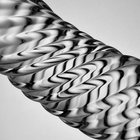 This close-up, monochrome photo shows details of a glass, helix objet d'art.