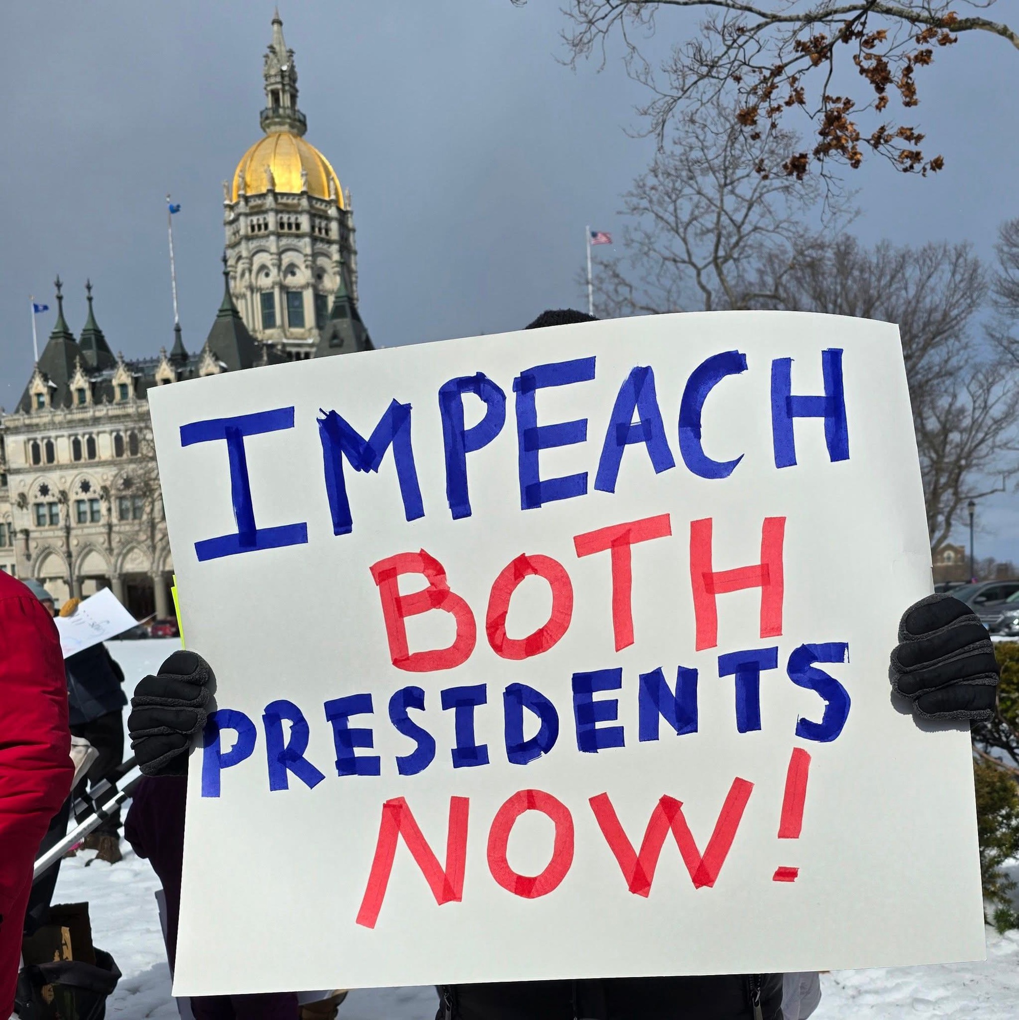 Sign that says impeach both presidents in blue and red writing