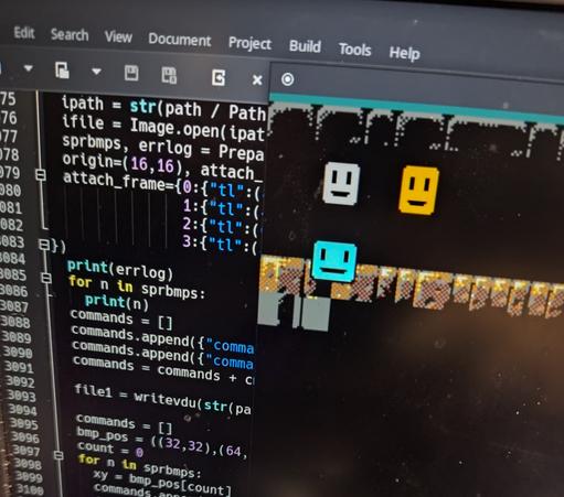 Some Python code(the build system) and the demo in an emulator window, showing some tile spam using OpenGameArt assets and some Megazeux-style smiley faces