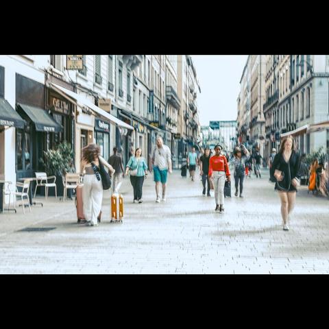 Photo de rue , une personne isolée habillée de rouge au milieu de personnes  flous .Lyon,France