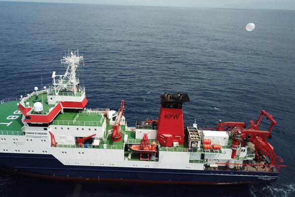 Drone shot of the research vessel Maria S. Merian. A balloon carrying a radiosonde is launched from the rear of the ship.