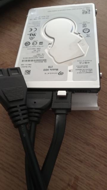 A 2TB 2.5 inch internal Hard Drive.
There are 3 cables visible. Only two are plugged in - the SATA power and data connectors. The other unplugged cable is an IDE power cable which is only used on that type of drive.