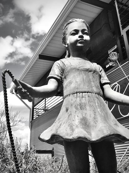 Statue, black and white, little girl jumping rope.