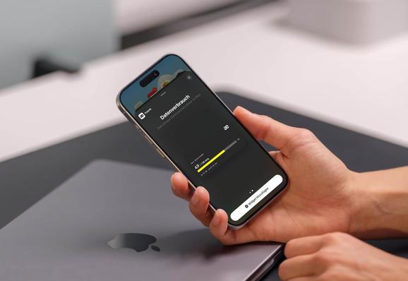 Eine Person hält ein iPhone in der Hand, auf dem der aktuelle Datenverbrauch von fraenk angezeigt wird.