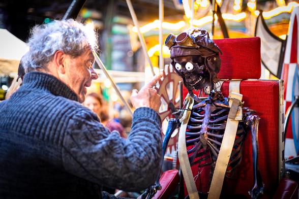 Eine Person zeigt mit dem Finger in Richtung einer Skelettes mit Augen