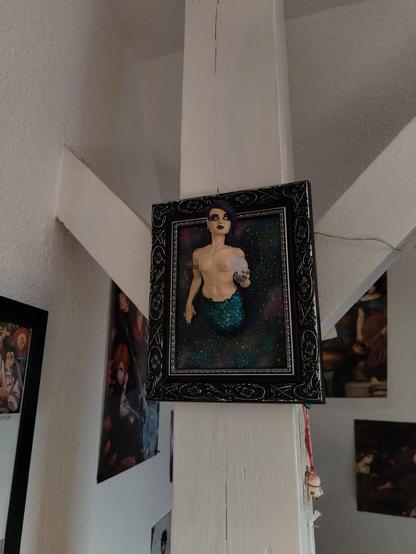 the frame hanging in the client's home on a white wooden post, some other art visible around her.
