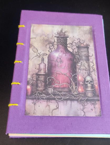 Handmade notebook, hardcover with exposed spine. Binding style: coptic stitch, using yellow thread. Book cover purple. On the front cover there is an image of a purple fantasy style bottle with a light-purple liquid inside.