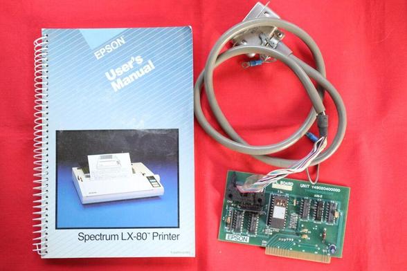 Left: spiral bound user's manual for the Epson Spectrum LX-80 printer.

Right: Expansion card attached to a centronics parallel printer cable