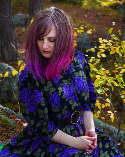 Portrait of a purple haired woman in an autumn forest wearing a vintage dress