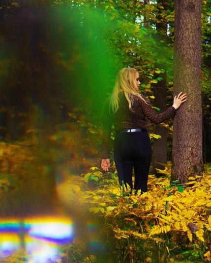 Portrait of a blonde woman in an autumn forest with yellow leaves