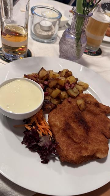 Das Bild zeigt ein Kochkässchnitzel mit Bratkartoffeln