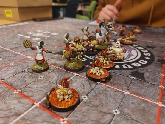 Squirrels on skull piles on lava bases standing off against Amish women hobgoblins, chaos dwarf Amish farmers and a cow