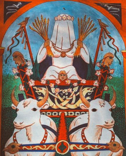 Das Bild zeigt eine stilisierte und farbenfrohe Illustration der Göttin Nerthus, die auf einem Wagen sitzt, der von zwei weißen Ochsen (oder Ziegen?!) gezogen wird. Nerthus ist in weiße Gewänder gekleidet, trägt eine Blumenkrone auf dem Kopf und hat einen Schleier über dem Gesicht. In beiden Händen hält sie Bündel aus Weizen und trägt eine Halskette mit einem großen Anhänger. Der Wagen ist mit Blumen verziert und wird von zwei Stangen mit Vögeln an der Spitze flankiert. Im Hintergrund ist ein blauer Himmel mit einem Bogen, der die Szene einrahmt.