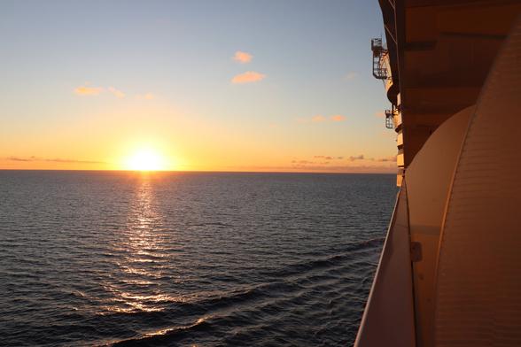 Photo of the sun setting over the ocean.