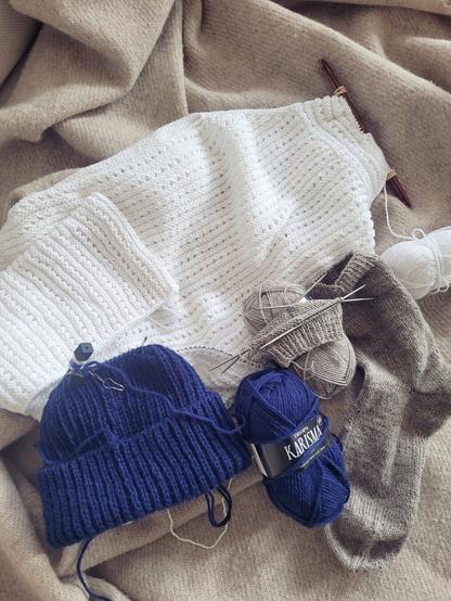 ENG 3 unfinished knitting projects: a white Blouse No. 2, a blue Ole Hat and a greige pair of plan socks.

DEU 3 halbfertige Strickprojekte: eine weiße Blouse No. 2, eine blaue Ole Mütze und ein Paar Socken in Greige