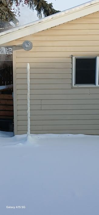 A tower of condensed water below a natural gas garage heater vent. Now 14 siding panels tall. Was only 12 a couple days ago.