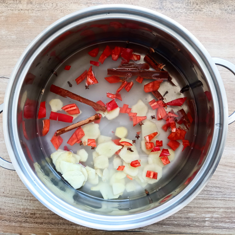 in einem Topf Wasser, Zucker, geschnittene Chili, Zimtstange + Nelken