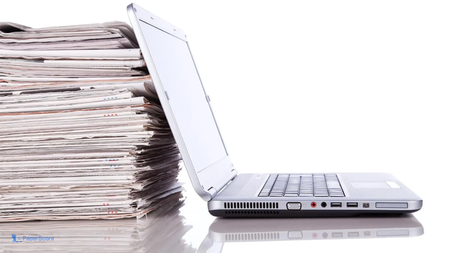 photo - laptop in front of a stack of paper