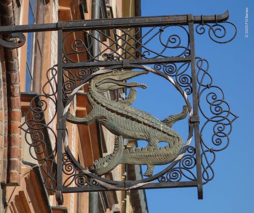 An elaborate wrought-iron sign featuring a crocodile, Warsaw