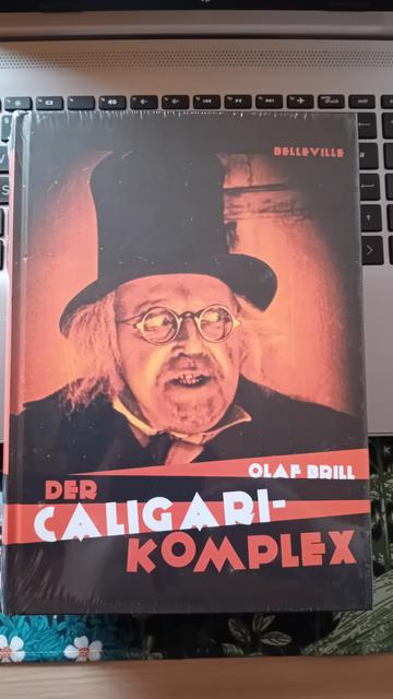 Buch mit dem Titel "Der Caligari-Komplex" von Olaf Brill. Auf dem Cover sieht man den Schauspieler Werner Krauß in Nahaufnahme in der Rolle des Dr. Caligari