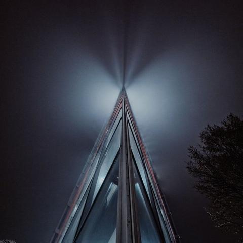 Scharfe Glaskante des Viktoriaturms in Mannheim bei Nacht mit Lichtreflexen.
