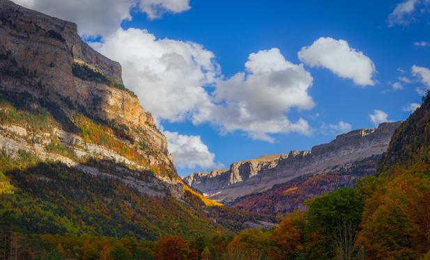 Panoramic view of several photos showing part of the Ordesa Park (Huesca) in autumn at sunset. Mountains and part of the vegetation with the colours of this season can be seen.