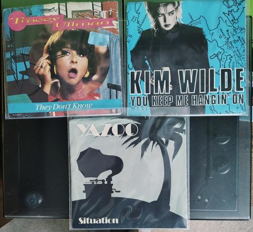 Three 45rpm 7" records in picture sleeves. They are They Don't Know by Tracey Ullman, You Keep Me Hanging On by Kim Wilde and Situation by Yazoo.