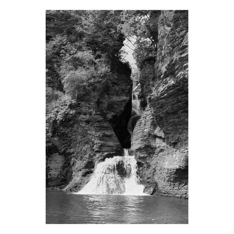 waterfall pouring through rock gap into serene pool