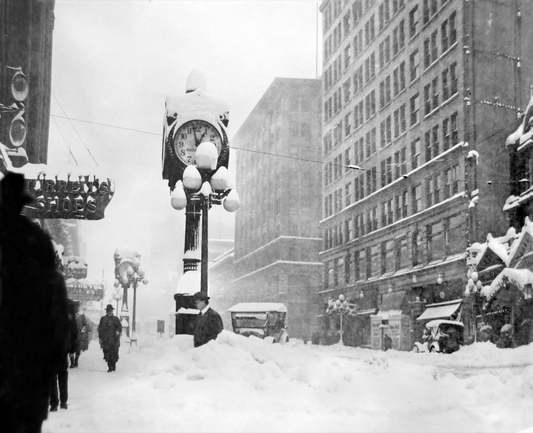 Black and white image, the Big Snow of 1916 trims two jewelers’ clocks on the west side of Second Avenue, north of Marion Street, in Seattle, Washington, USA.