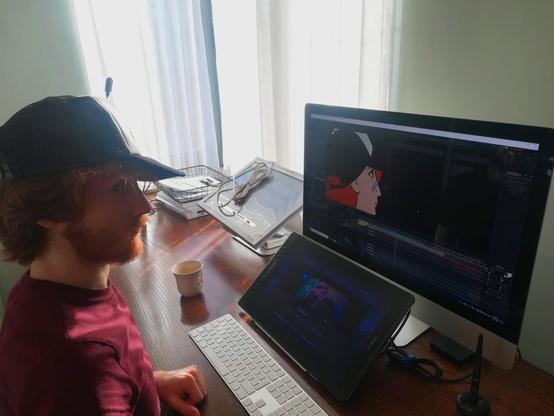 Sitting behind my desk. Working in After Effects: compositing and VFX for the feature film 'Where Is Anne Frank?' from Oscar Winner Ari Folman. Wearing the same hat as Kitty, the main character in the film. I'm working on an iMac and Huion Tablet, back in the year 2020.