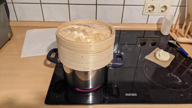 This picture is showing the bamboo steamer on a pot in action