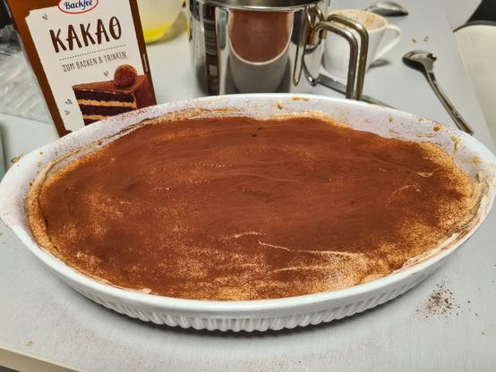 Ein Tiramisu auf einem grauen, schmutzigen Küchentisch