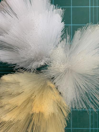Three sets of fibre optic bundles showing clear, light yellow, and dark yellow fibres after extensive cleaning and accidental production of non-Newtonian fluid as a cleaning byproduct.