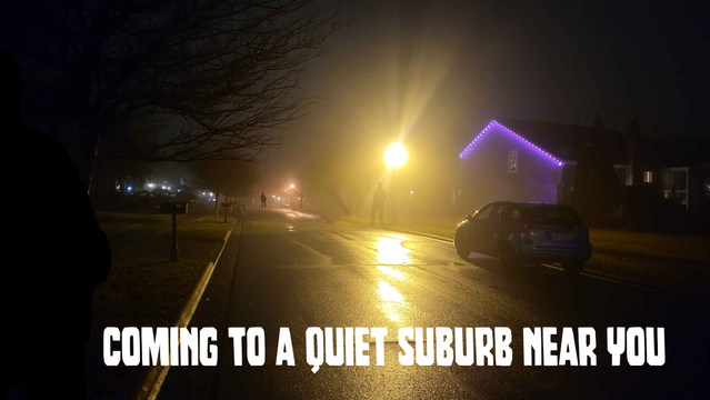 A foggy suburban street at night. A lone car sits under a  bright street light. Several shadowy figures appear in different places. Some almost impossible to notice.