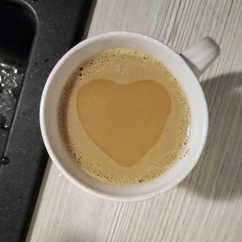 Draufsicht auf einen gefüllten Kaffeepott: der sich zurück ziehende Schaum hat ein Herz freigegeben