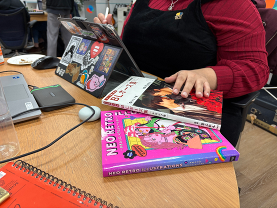 Someone putting their hand on a BL Pose book and a Neo Retro book.